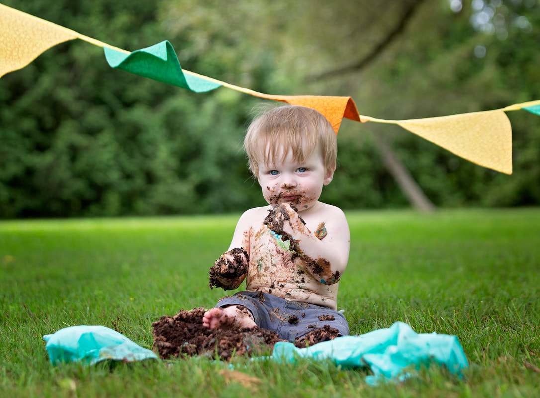 Baby eating a chocolate cake outside on the grass birthday cakesmash