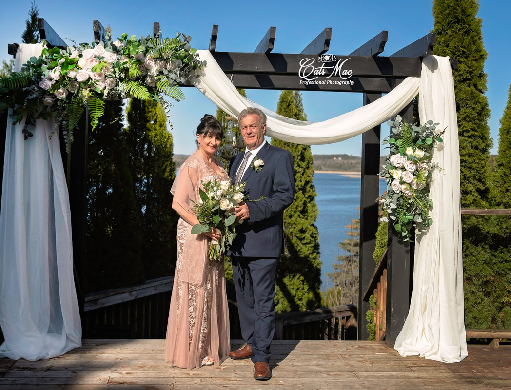 Wooden arch flowers bride groom Stillwater on the Lake
