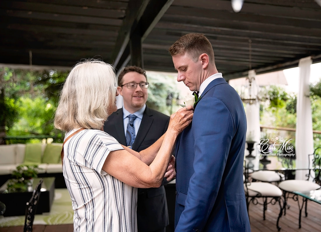 Groom and mother pinning on boutonniere at Stillwater on the Lake 