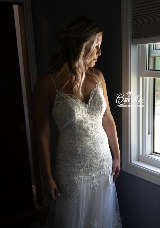 Bride looking out window natural light