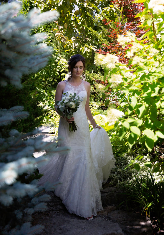 bride walking down stone path at Stillwater on the Lake Gardens