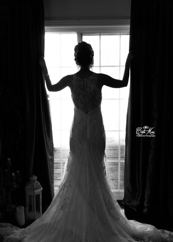 Black & white bride looking out window backlit Stillwater on the Lake