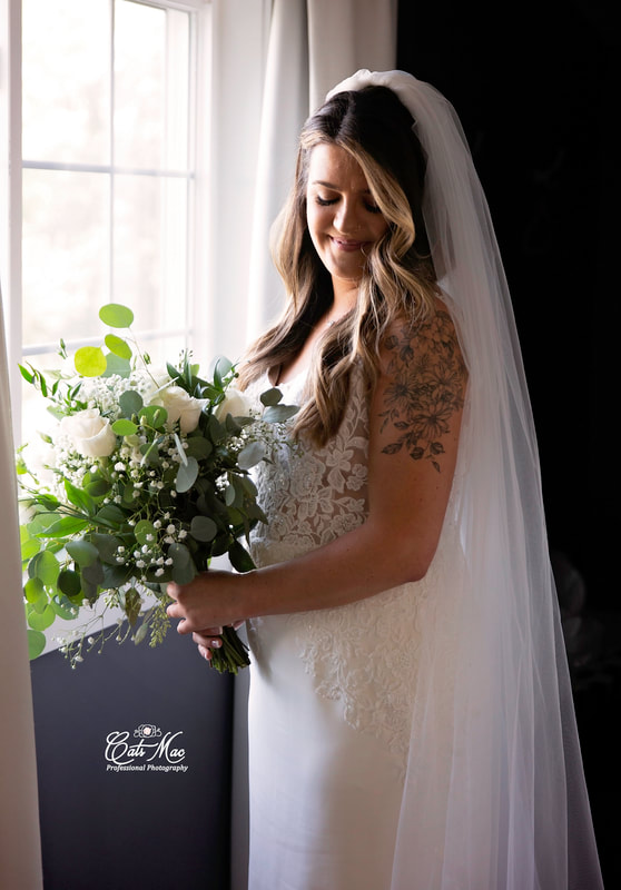 Stillwater on the Lake intimate elopement bride at window looking at bouquet