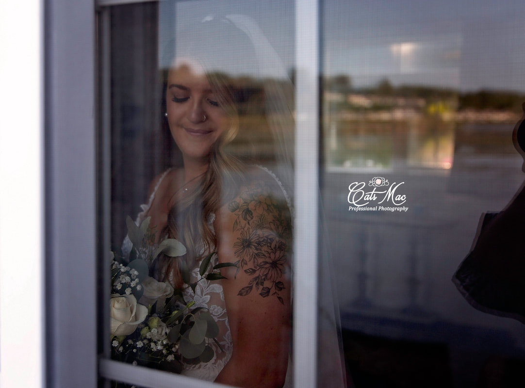 Stillwater on the Lake elopement bride looking out window holding bouquet
