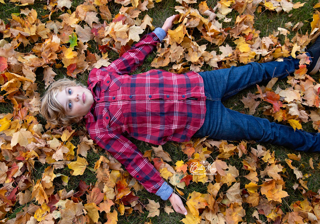 Boy in leaves making an angel fall photoshoot