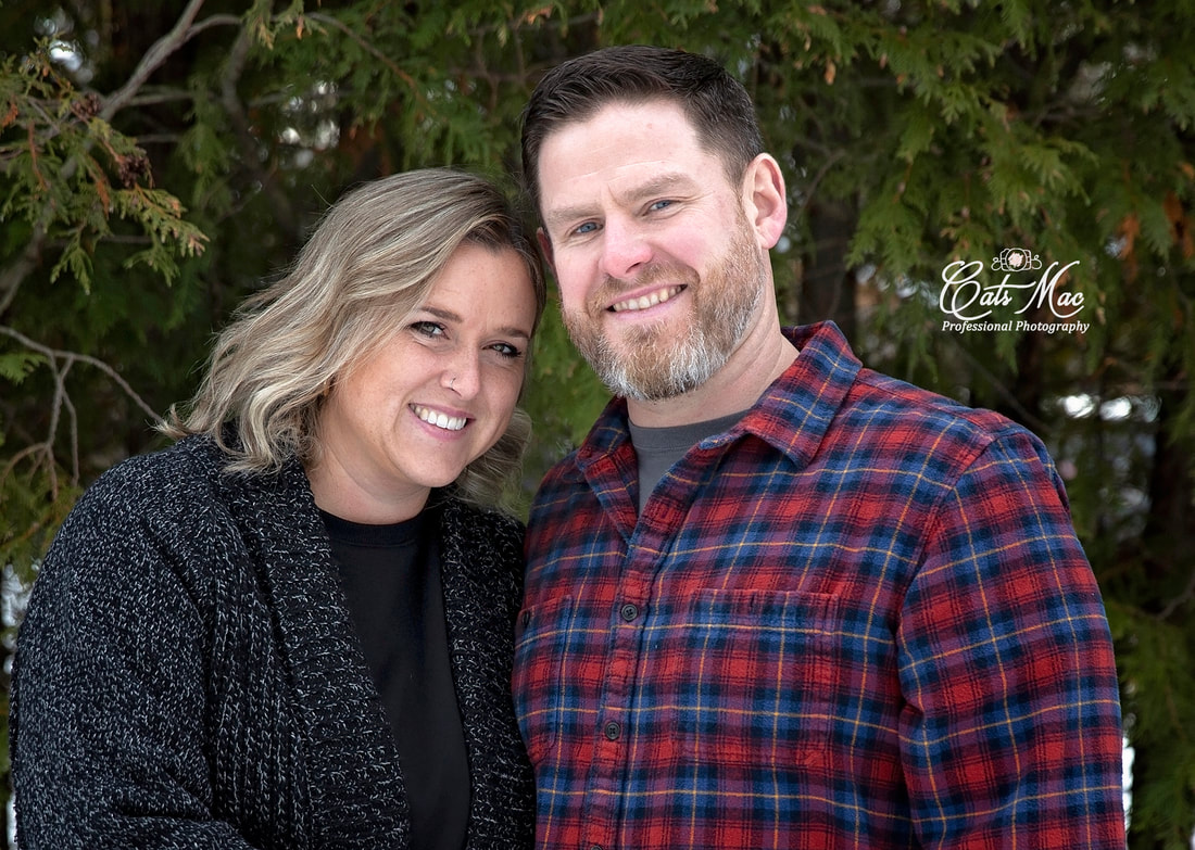 Couples photo session in winter outside against backdrop of evergreen trees