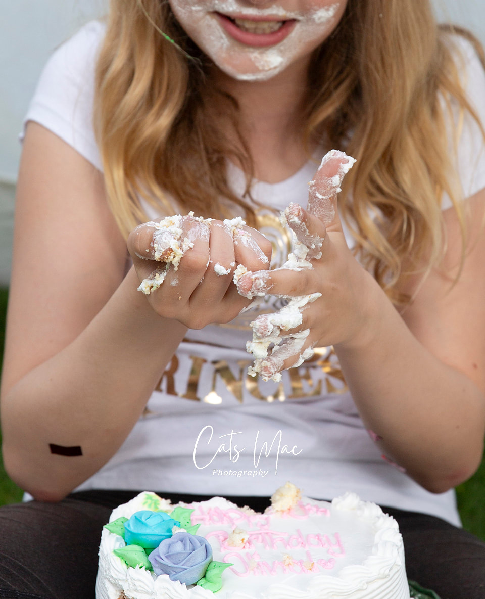 Messy hands full of icing from girls tenth birthday cake smash photo session