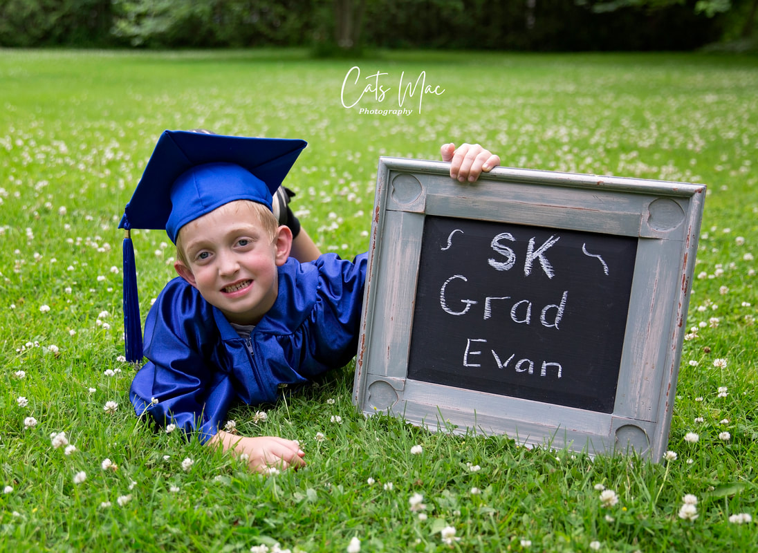 Photo session Kindergarten graduate holding sign outside SK grad