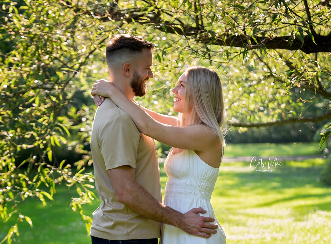 Photo Session of man and woman facing each other in field under trees