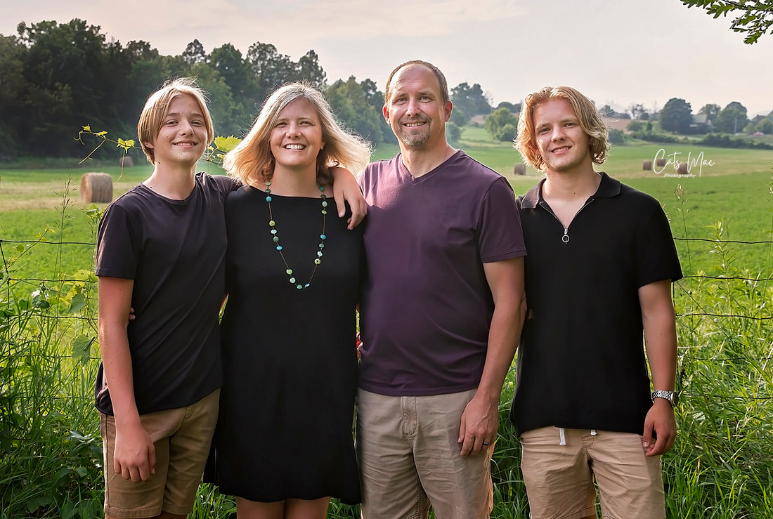 Family photo of mom, dad and teenage boys country setting
