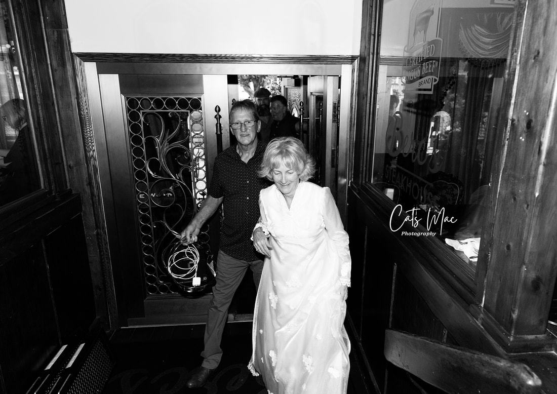 Couple coming into restaurant wearing wedding dress 50th anniversary photos