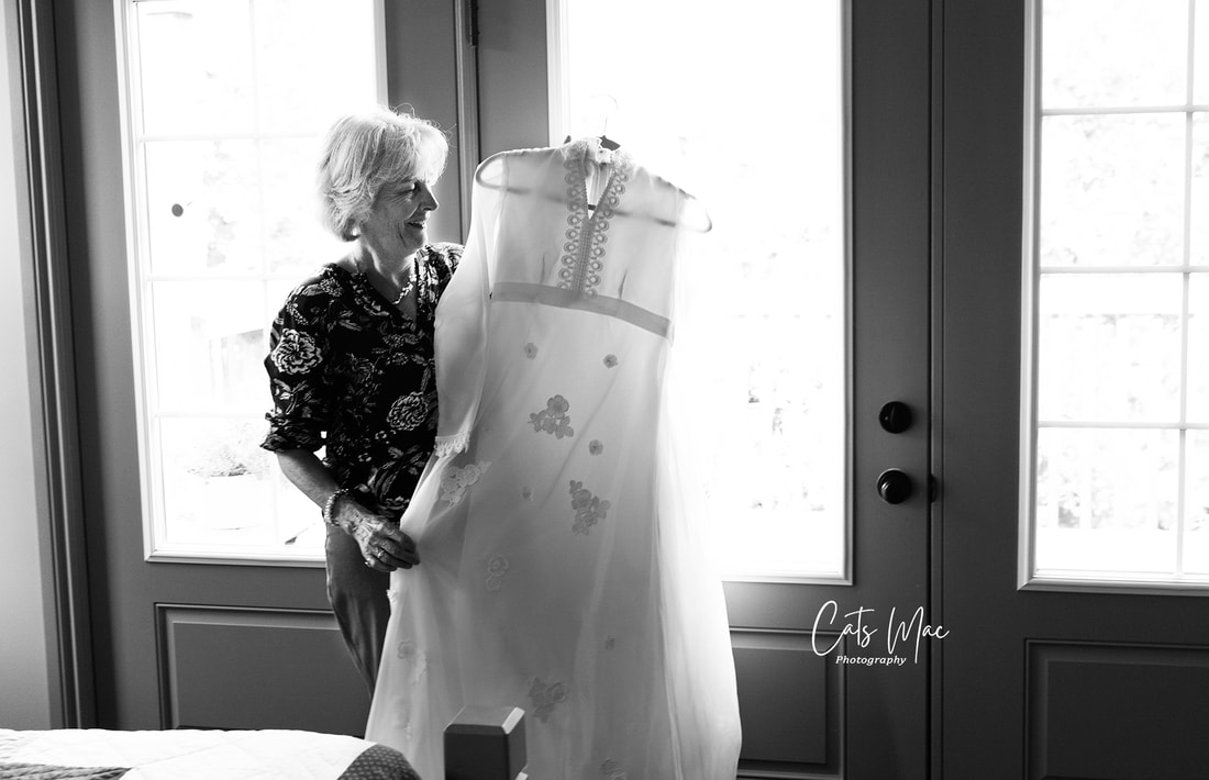 Woman holding her wedding dress up against the light of a window