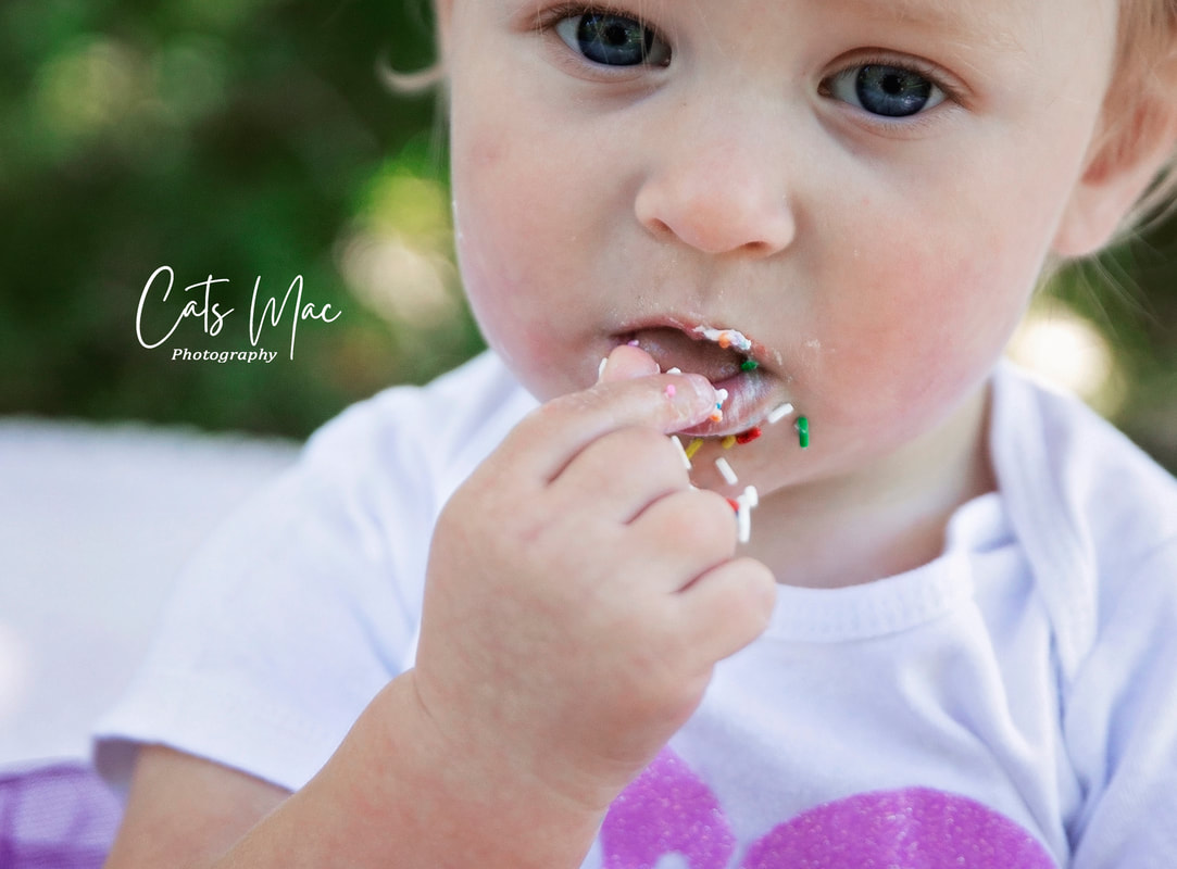 Close up of baby's mouth as she is eating her birthday cake outside cakesmash photo session 