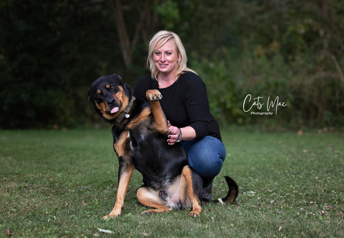 Woman and dog sitting on grass for Pet photo session. 