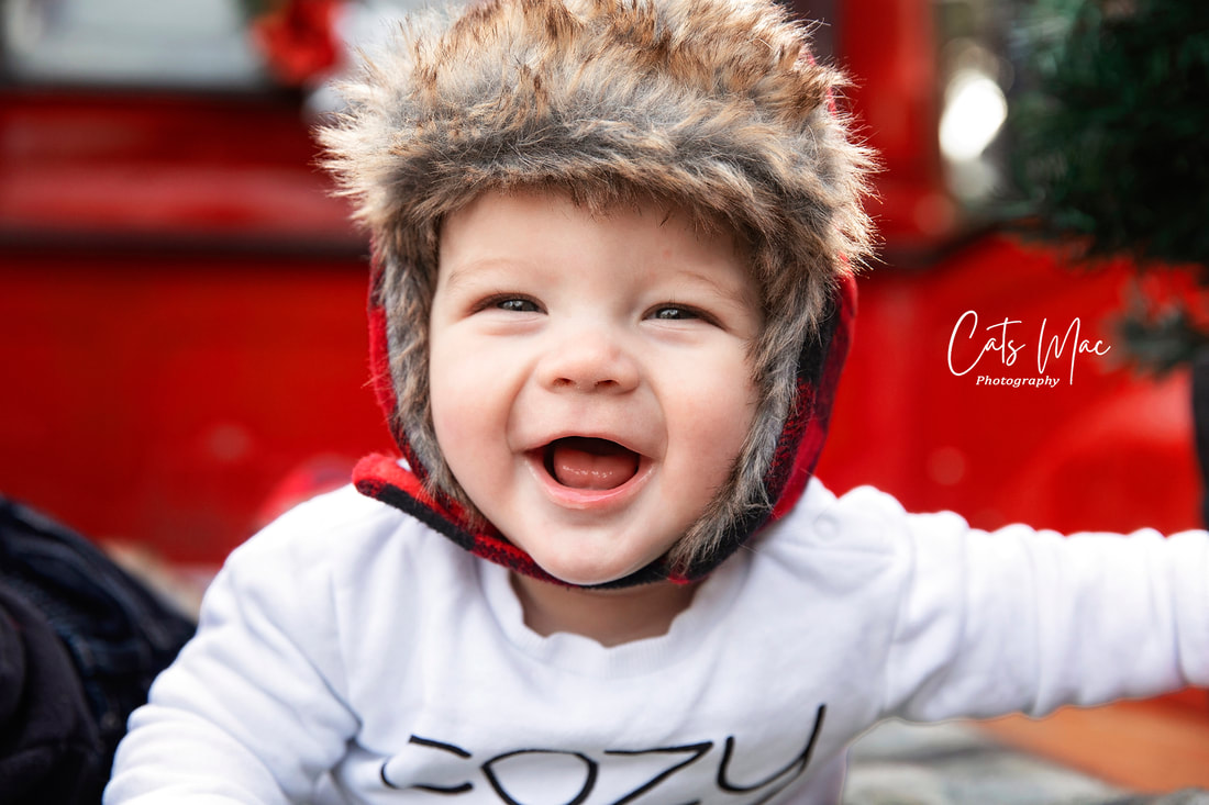 Baby boy in back of vintage red truck christmas photo session