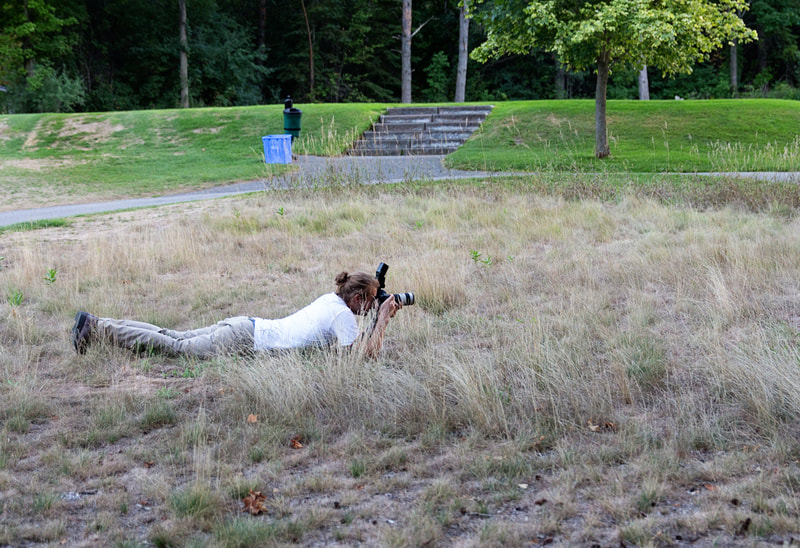 Justin Schofield wedding photographer in grass with camera