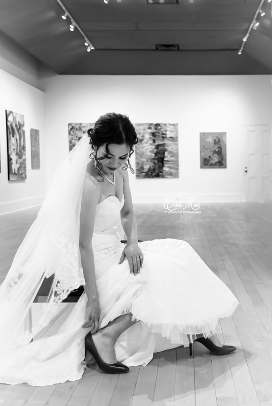 Bride formal photo sitting on chair reaching down for her shoe  Northumberland Art Gallery