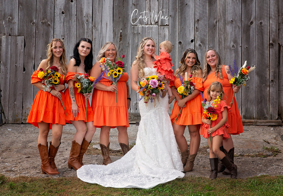 Bride and bridesmaids dressed in orange fall wedding with sunflower bouquets