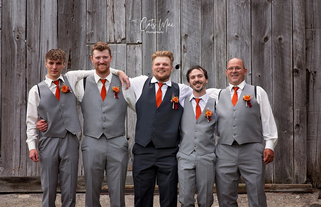 Groom and groomsmen with orange ties and boutonnieres