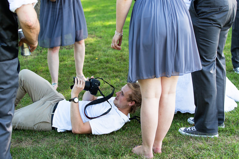 Justin Schofield wedding photographer on ground with camera