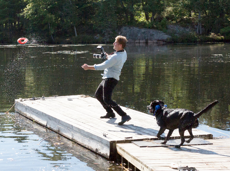 Justin Schofield photographer throwing rock with dog on dock 