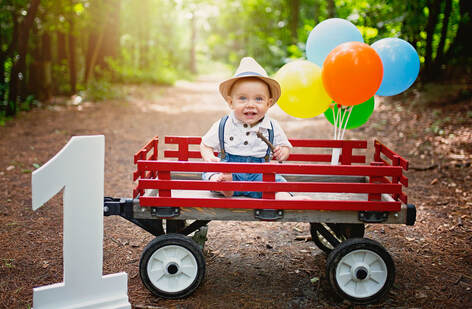 Outside birthday photo session with wagon and banner balloons